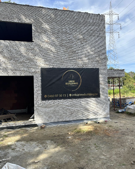 Ruwbouw met IMW Building werfbanner op de gevel