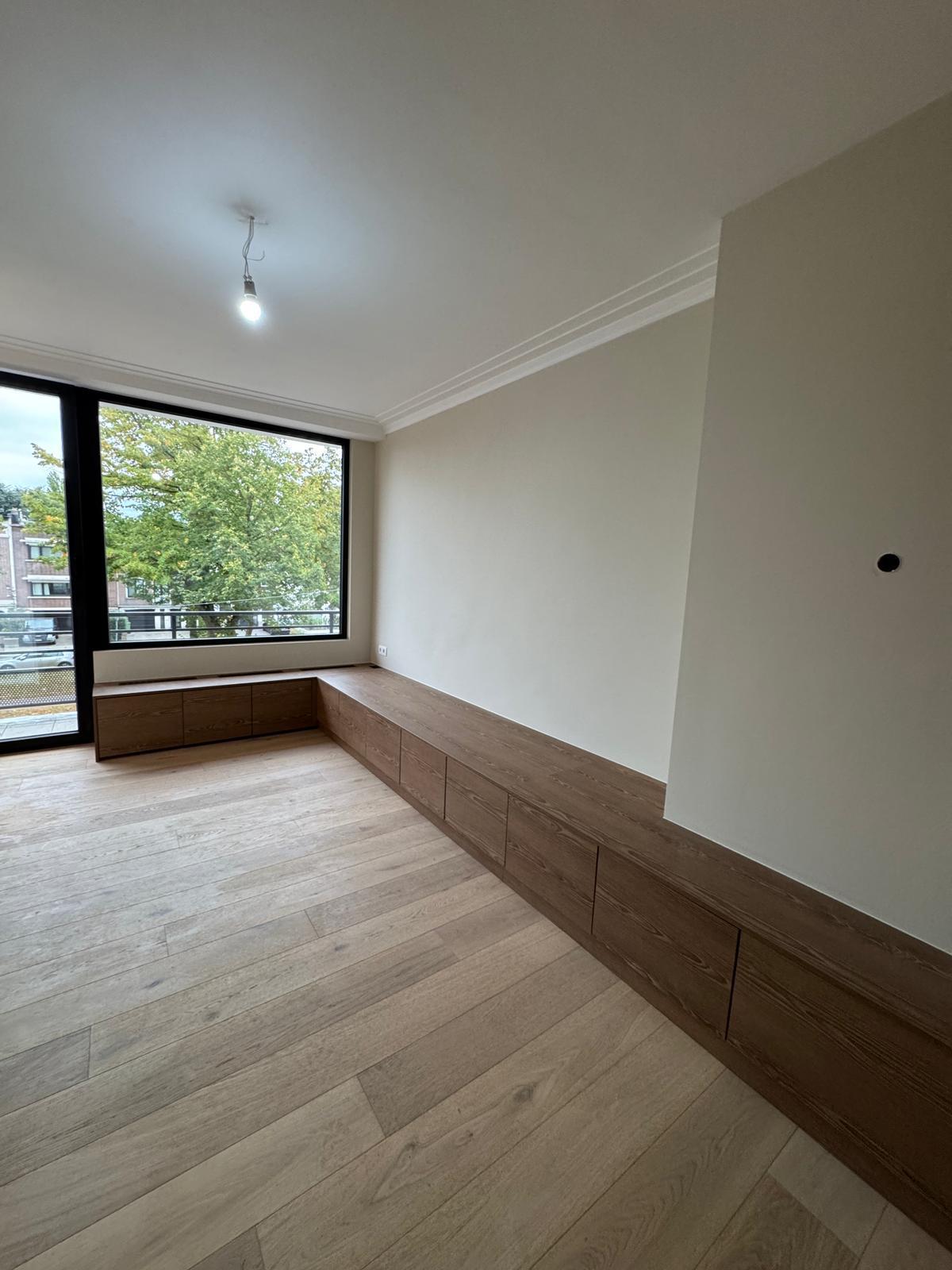 Leefruimte met houten vloer en maatwerk bergingsmeubel op maat