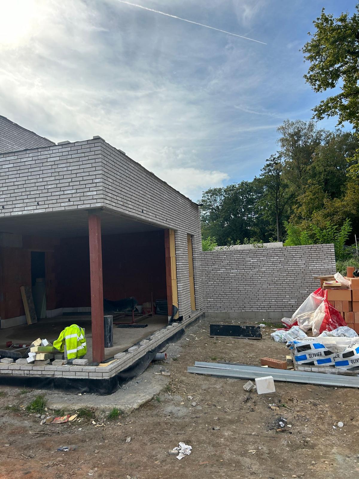 Overdekt terras met betonstructuur en stalen kolommen tijdens ruwbouw