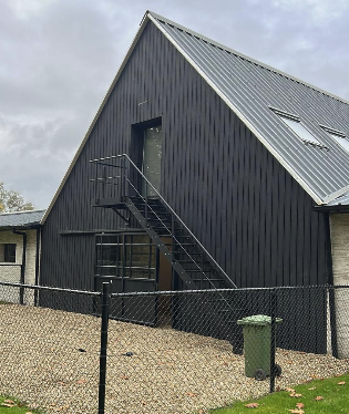 Zwarte gevelbekleding met stalen buitentrap na ruwbouw