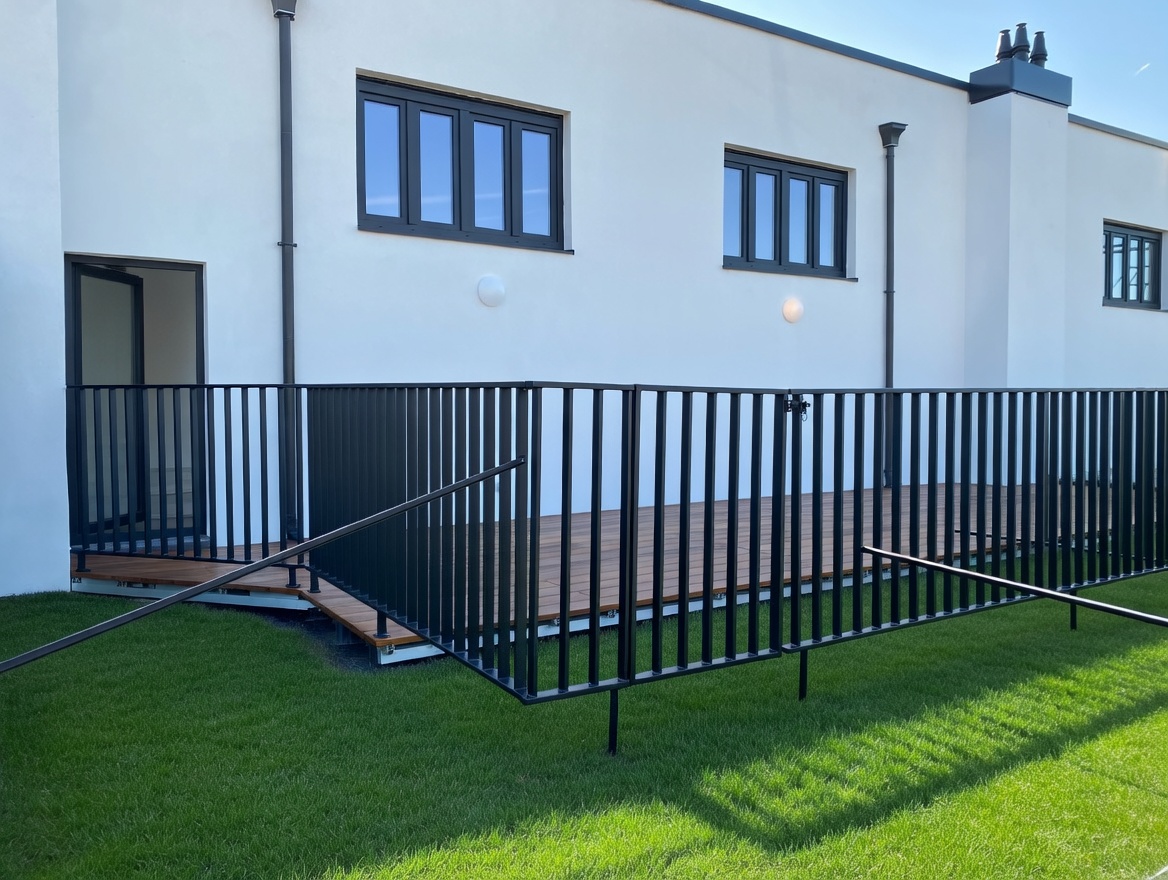 Afgewerkt terras met hardhouten vlonder en zwarte stalen balustrade bij nieuwbouwwoning
