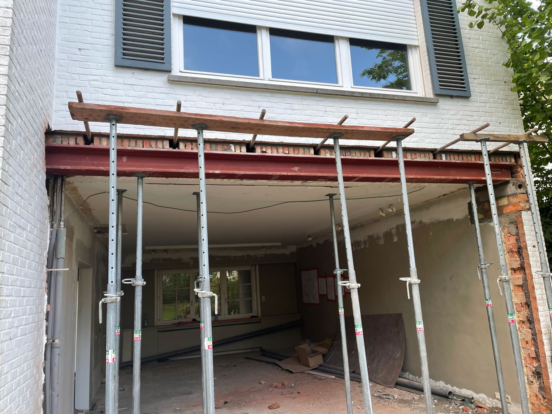 Structurele renovatie met stalen draagbalk en stempels bij het uitbreken van een dragende muur