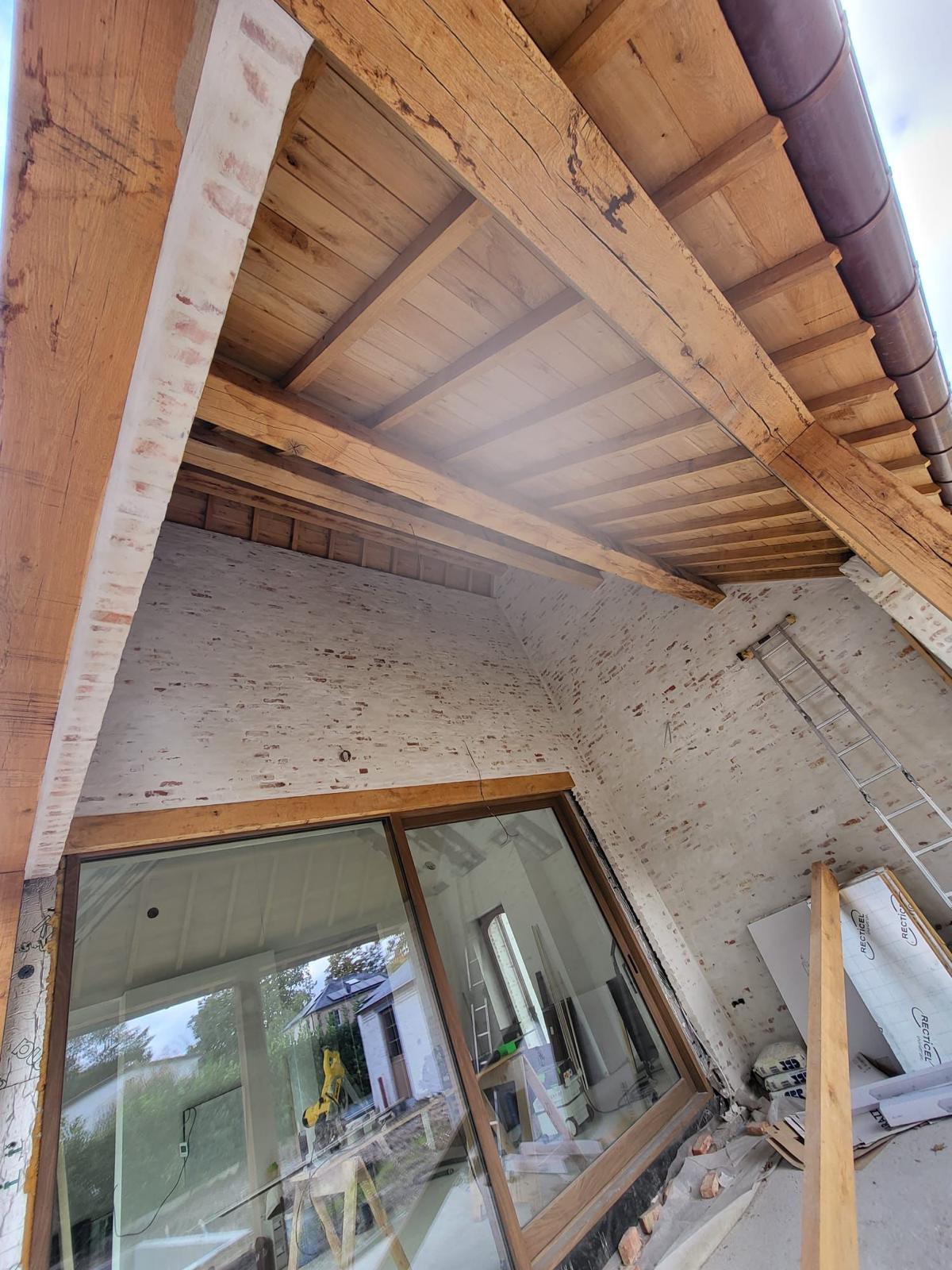Eiken balkenstructuur en overkraging boven raampartij bij renovatie met gekaleid metselwerk
