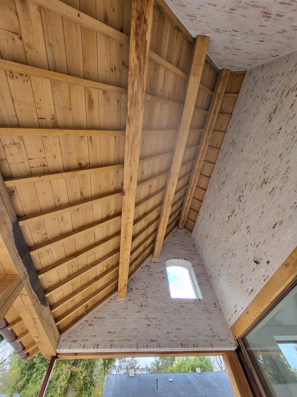 Renovatie met eiken dakstructuur, houten dakbeschot en gekaleide baksteenmuren