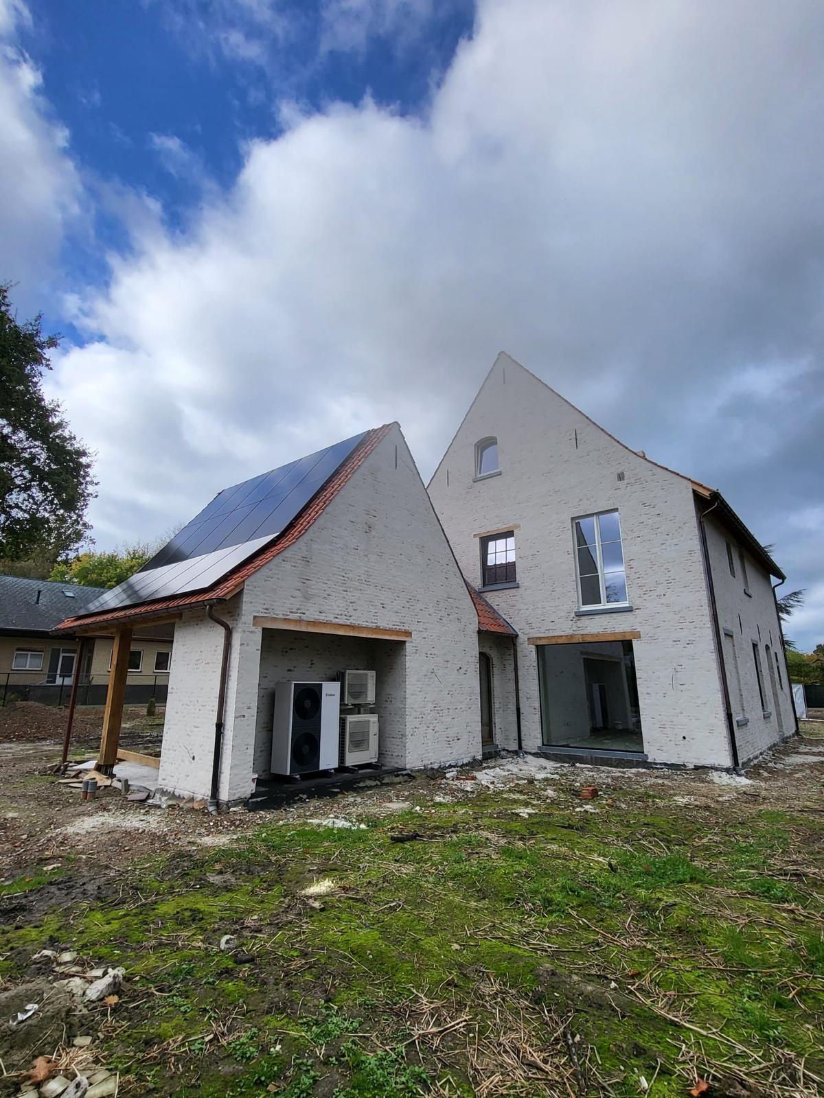 Achterzijde van landelijke nieuwbouwwoning met zonnepanelen en warmtepompen