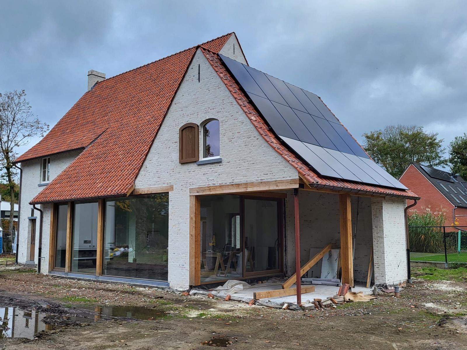 Nieuwbouwwoning met rode pannen, zonnepanelen en eiken overkapping aan de leefruimte