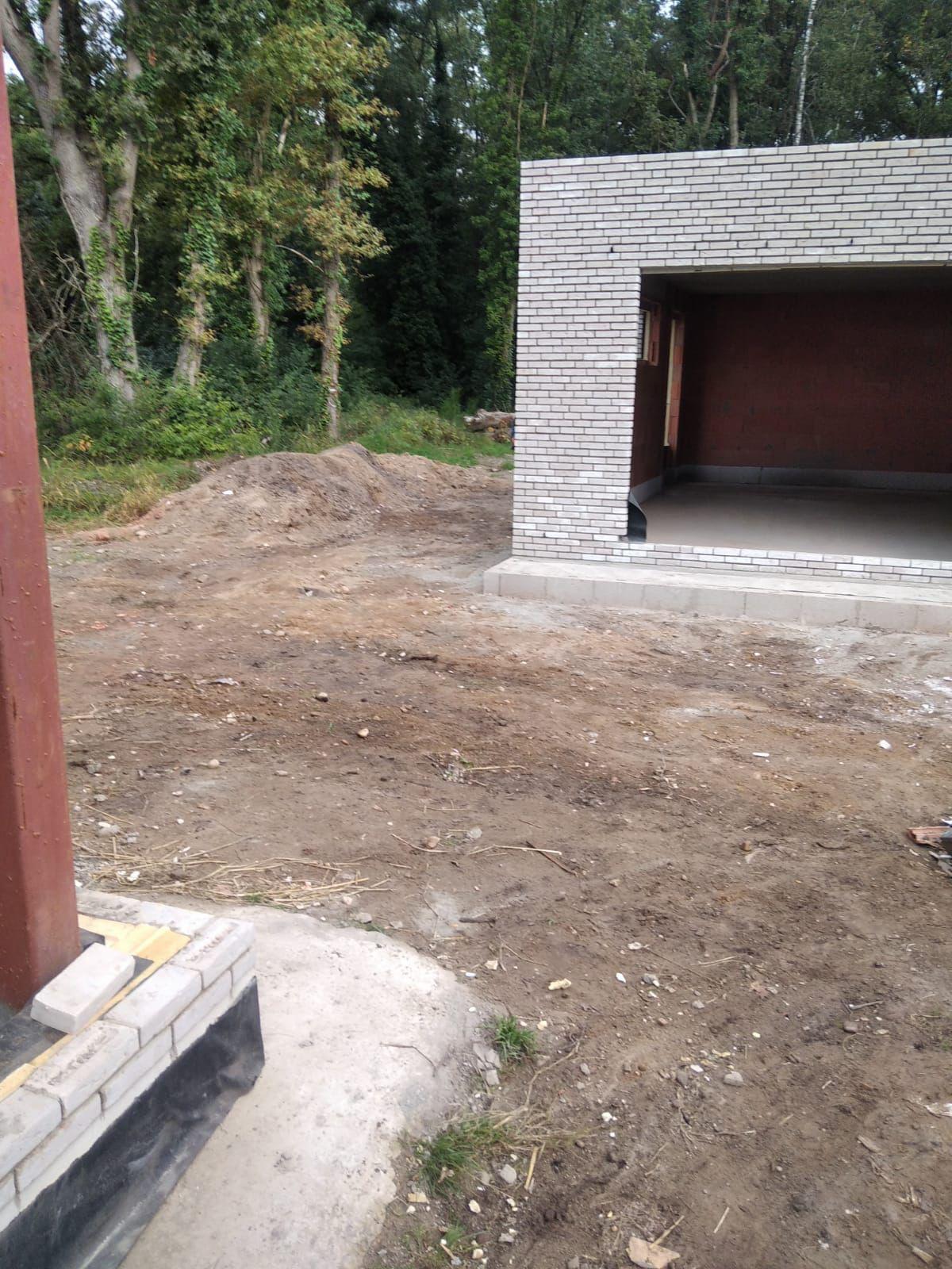 Vrijstaande garage in lichte baksteen met vlak dak op de werf